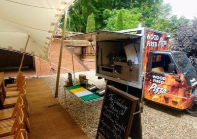Piaggio Truck set up to serve pizza at an event on a sunny day